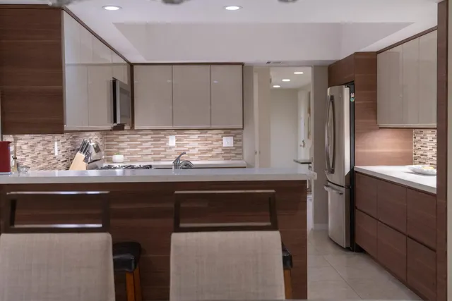 a kitchen with stainless steel appliances granite countertop a sink and a refrigerator
