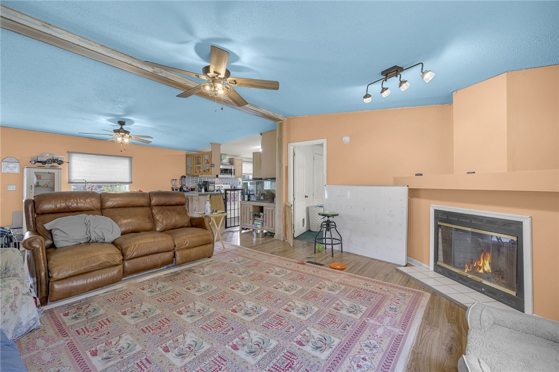 1549 Bethany Church Road Belton, SC 29627 - Photo 30 of 36 Warm wood-toned flooring flows through this living space featuring a cozy fireplace.
