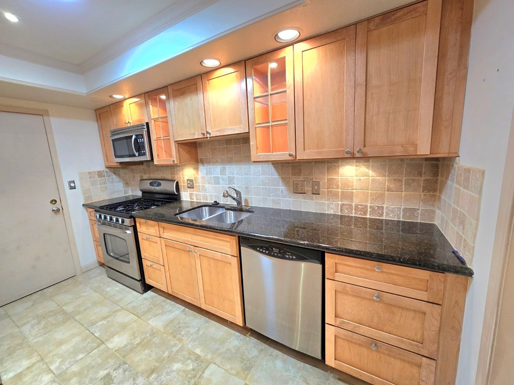 6851 Roswell Road Sandy Springs, GA 30328 - Photo 9 of 19 a kitchen with stainless steel appliances granite countertop a stove a sink and a microwave