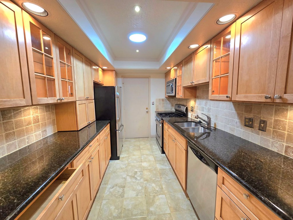 6851 Roswell Road Sandy Springs, GA 30328 - Photo 10 of 19 a kitchen with stainless steel appliances granite countertop a sink a stove and a wooden floors