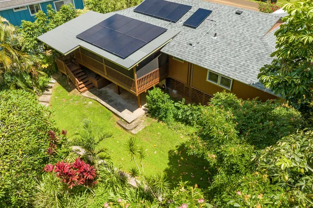 an aerial view of a house with a yard and swimming pool