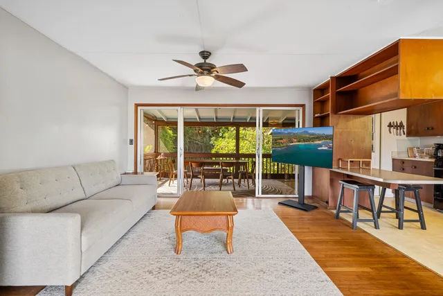 a living room with furniture a ceiling fan and a rug
