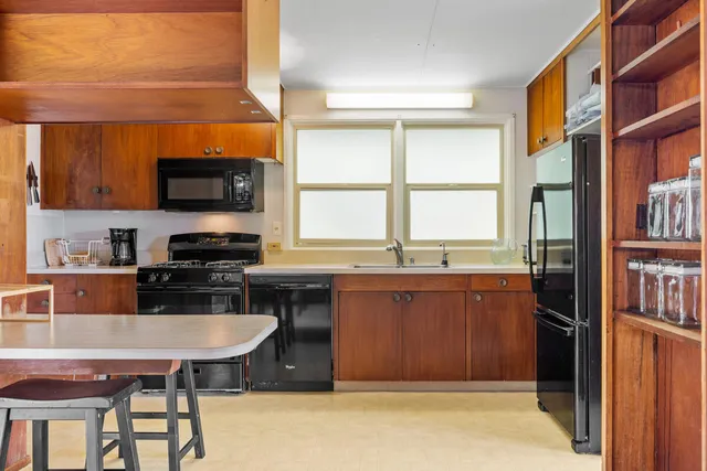 a kitchen with stainless steel appliances a stove a sink and a refrigerator