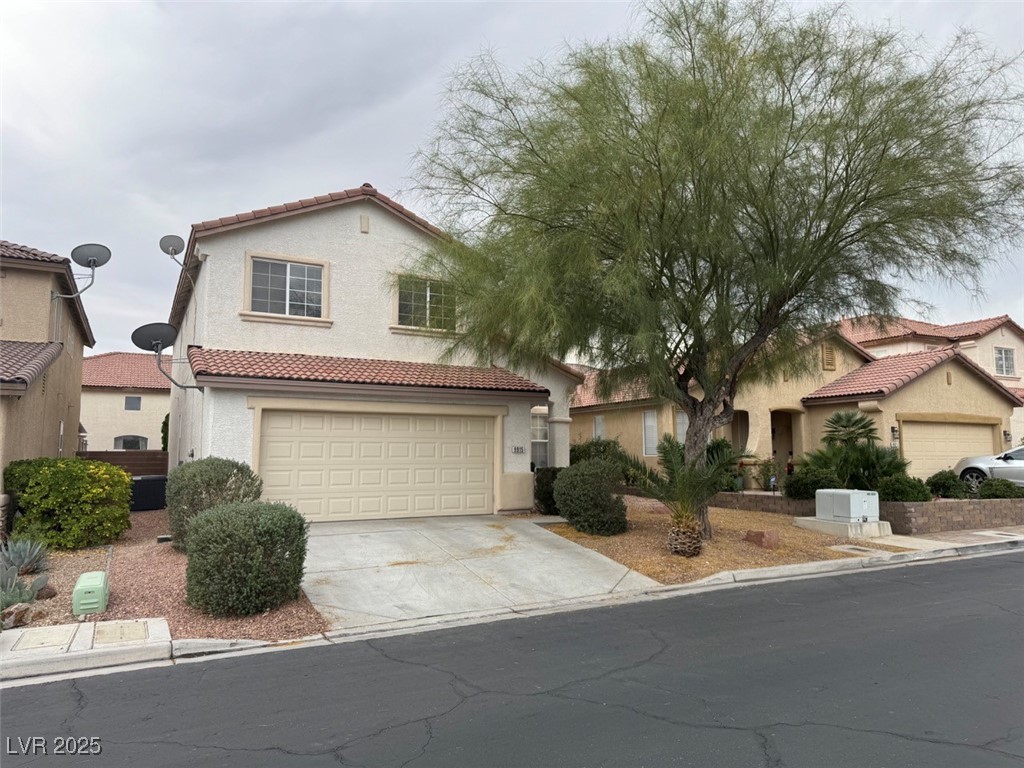 9915 Ridge Hill Avenue Las Vegas, NV 89147 - Photo 2 of 17 Mediterranean / spanish home featuring concrete driveway, a tile roof, and stucco siding