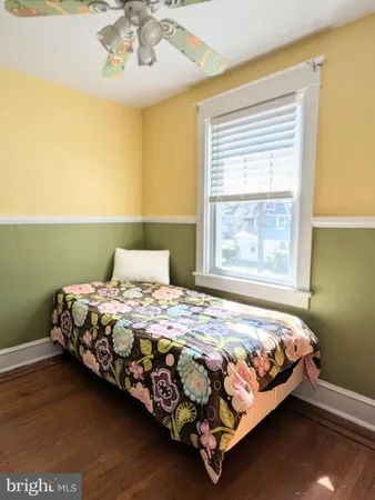 a bedroom with a bed wooden floor and a window
