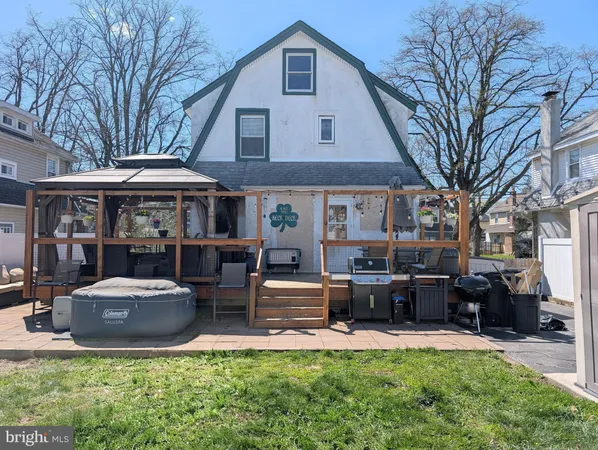 a front view of a house with garden and trees