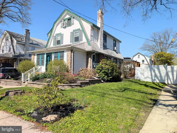 a view of a white house with a big yard and potted plants
