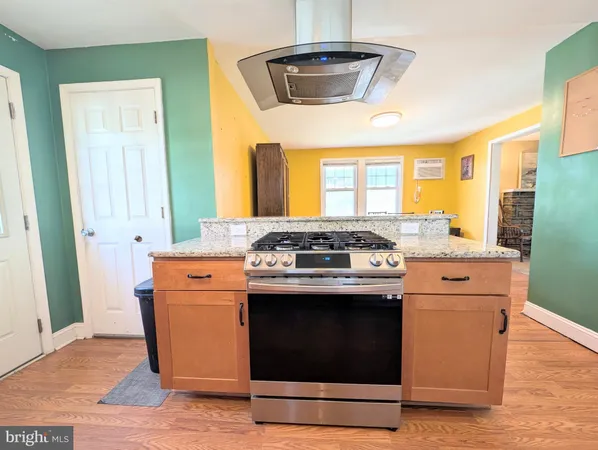 a kitchen with stainless steel appliances wooden floor sink and wooden cabinets