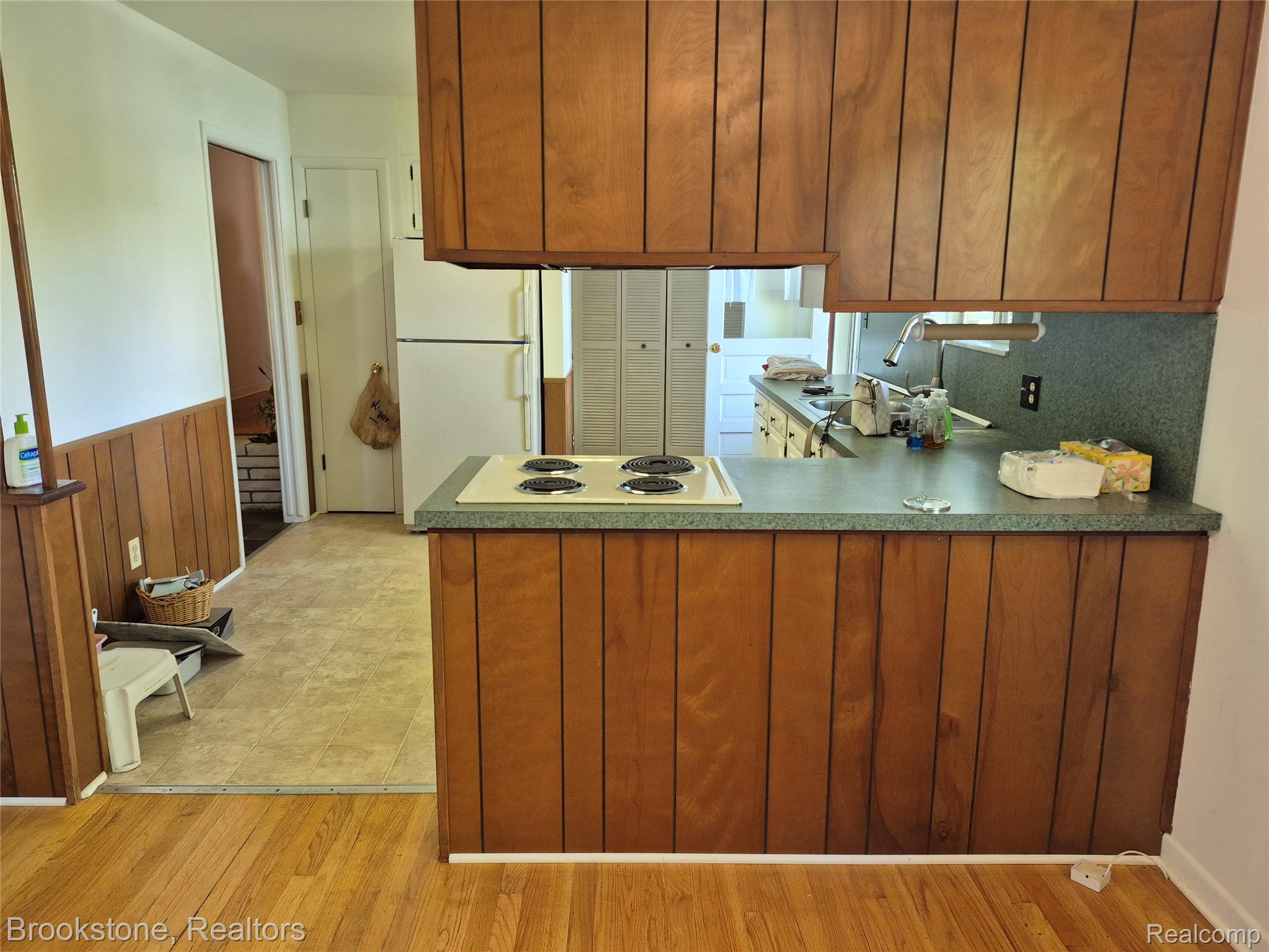 4295 Sashabaw Road Waterford, MI 48329 - Photo 15 of 37 Kitchen area featuring wood paneling, an integrated electric range, and laminate countertops