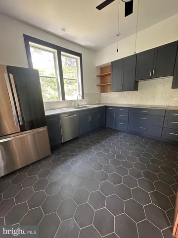 a kitchen with stainless steel appliances a sink a stove a refrigerator a counter top space and cabinets