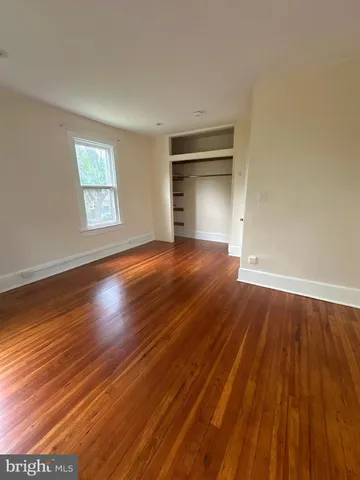 a view of empty room with wooden floor and fireplace