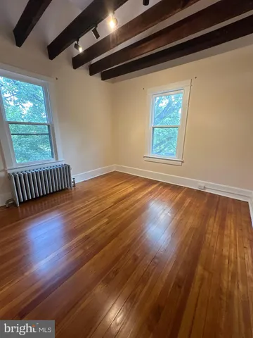 a view of room with window and wooden floor