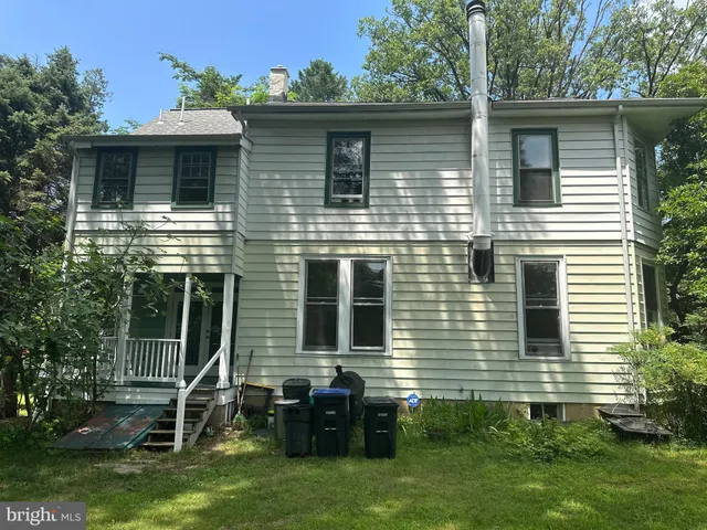 a view of a house with a yard and a large tree