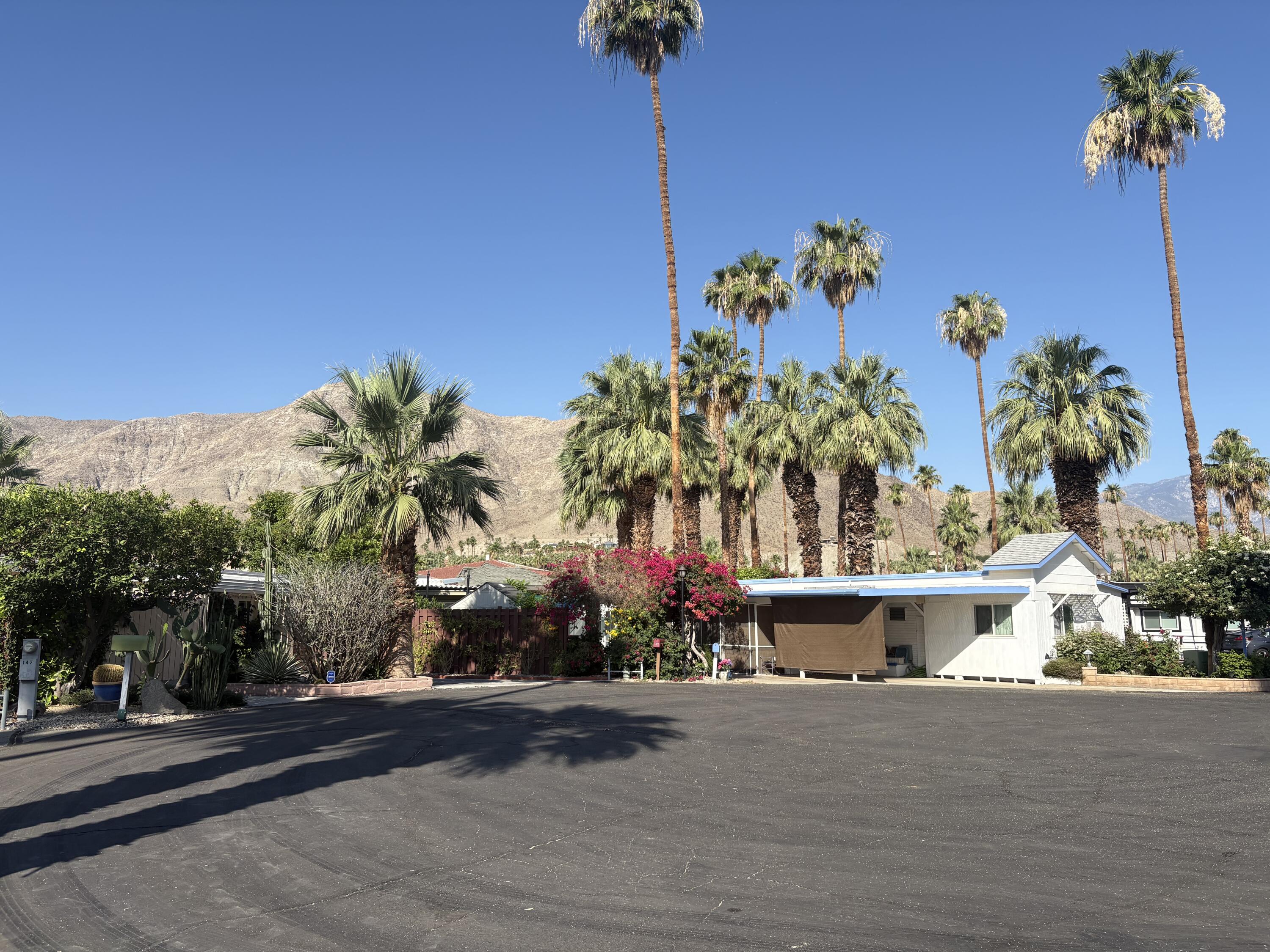 70260 Highway 111, Unit 148 Rancho Mirage, CA 92270 - Photo 2 of 36 a front view of a house with a yard and a garage
