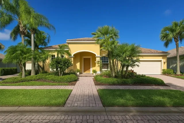 a front view of a house with a yard and potted plants