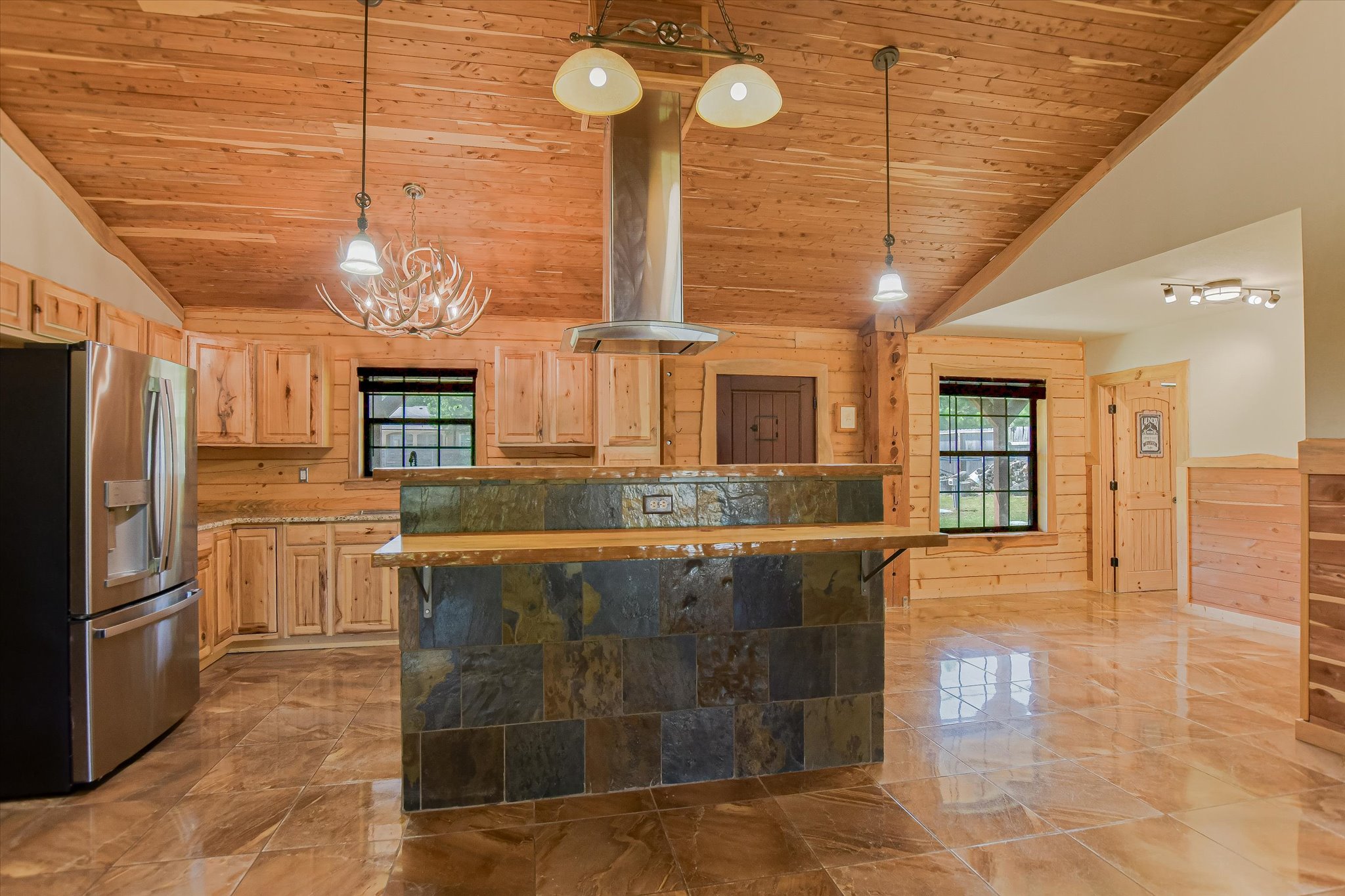218 Cardinal Loop Paige, TX 78659 - Photo 8 of 22 A well-appointed kitchen features rich wooden cabinetry, tile flooring, and a stone-clad island, perfect for entertaining.