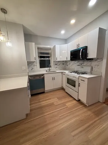 a kitchen with stainless steel appliances a stove a microwave a sink and cabinets