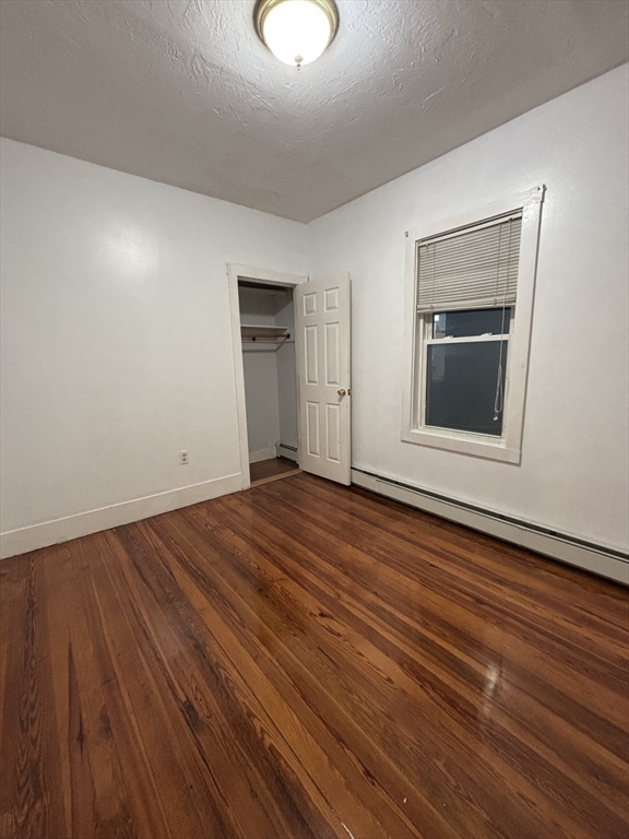 47 Middle Street, Unit 2 Boston, MA 02127 - Photo 6 of 13 an empty room with wooden floor and windows
