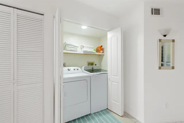 a view of washer and dryer with bathroom in the background
