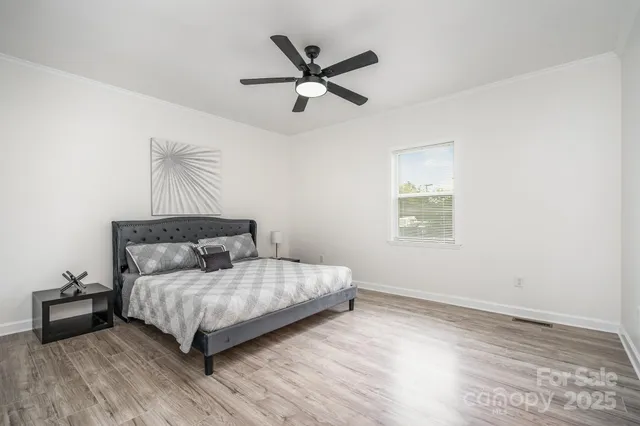 a bedroom with a bed and a chandelier fan