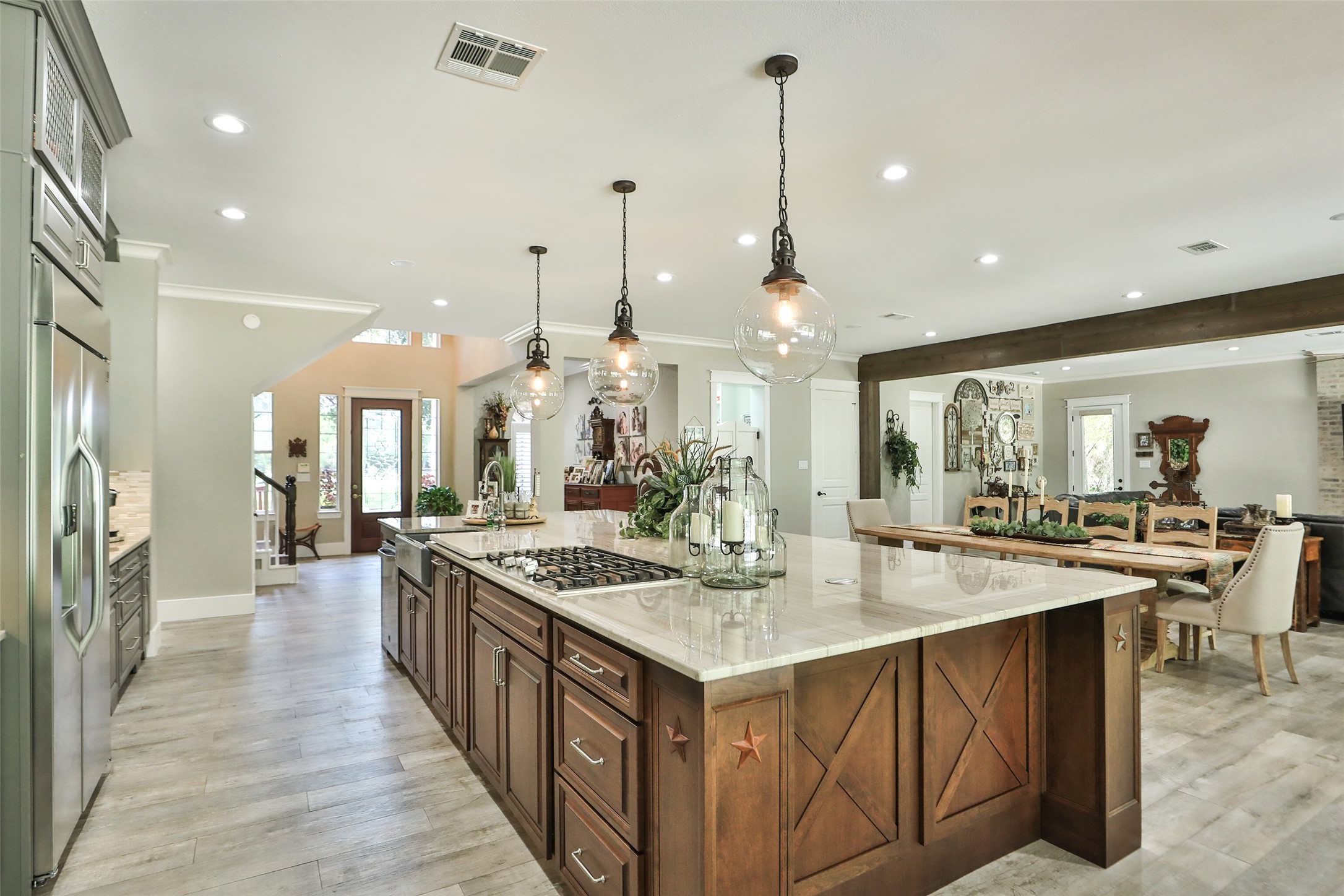 12126 Zion Road Tomball, TX 77375 - Photo 19 of 45 This kitchen is truly a showstopper. Outfitted with top-of-the-line LG Studio appliances, beautiful solid wood cabinetry, and stylish Pottery Barn pendant lighting, it perfectly blends function and design. The spacious island with a breakfast bar invites gathering, cooking, and entertaining, while the wood-like tile floors add warmth and durability.