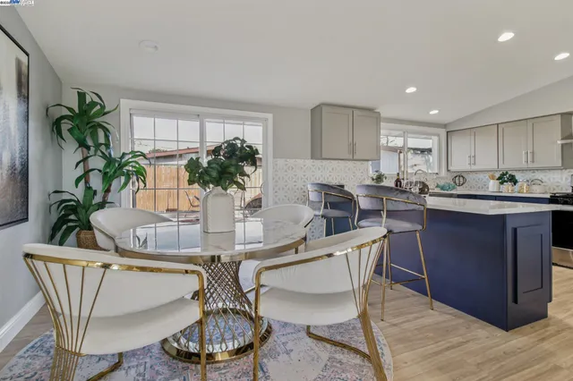 a dining room with furniture potted plants and wooden floor