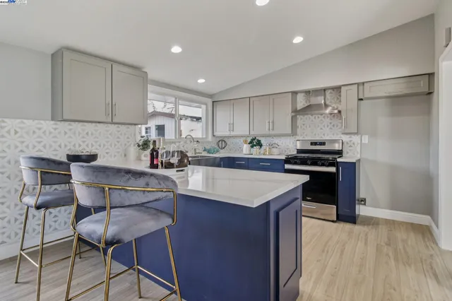a kitchen with kitchen island a sink counter and chairs