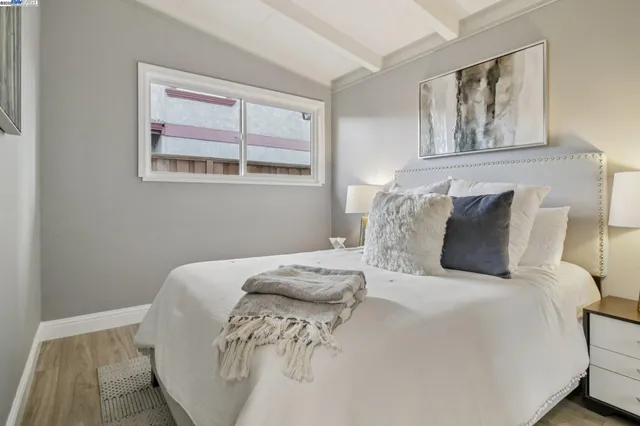 a large bed sitting in a bedroom next to a window