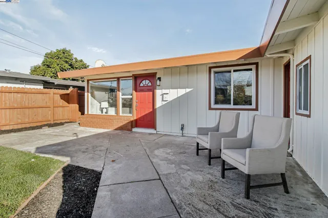 a view of a house with backyard and sitting area