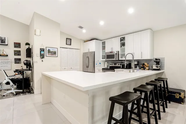 a kitchen with stainless steel appliances a refrigerator and a stove top oven
