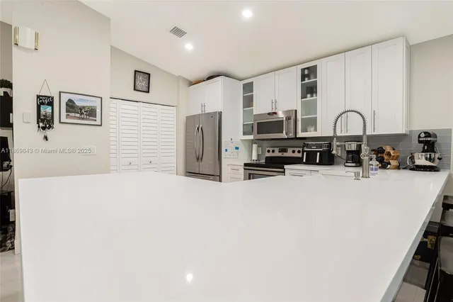 a large white kitchen with stainless steel appliances