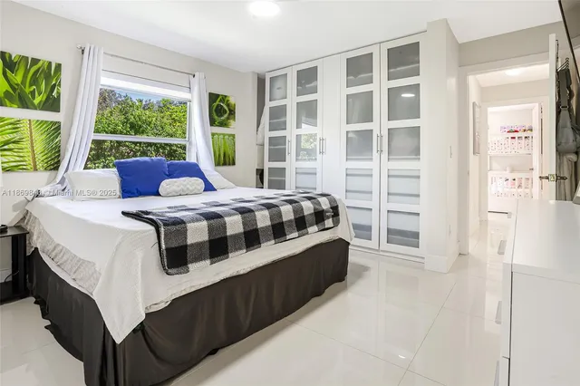 a bedroom with a bed next to a large window