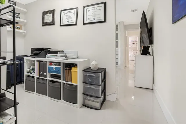 a view of a kitchen with fridge and workspace