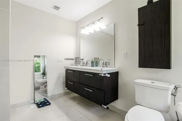 a bathroom with a toilet a sink and mirror