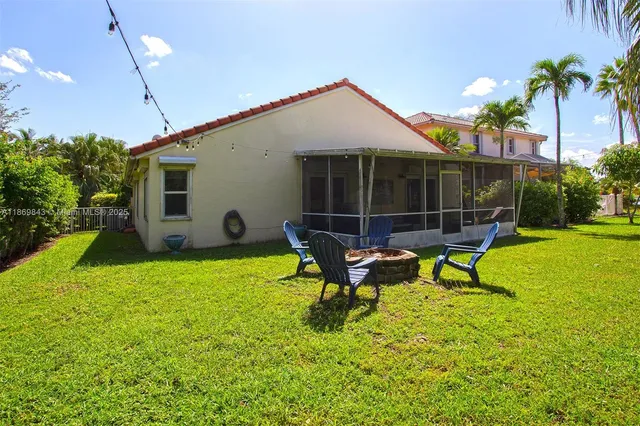 a view of a house with backyard and sitting area