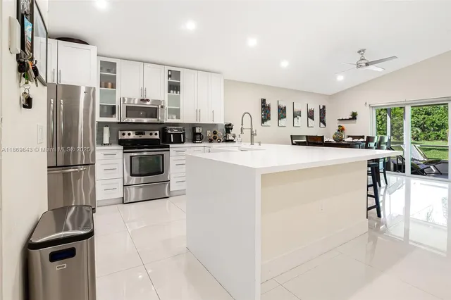 a kitchen with stainless steel appliances a stove refrigerator sink and cabinets