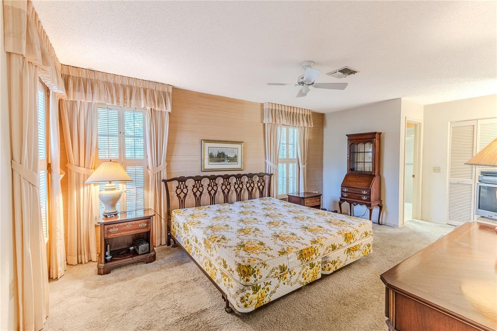 2193 Timber Lodge Lane Spring Hill, FL 34606 - Photo 32 of 73 a bedroom with a large bed and a chandelier