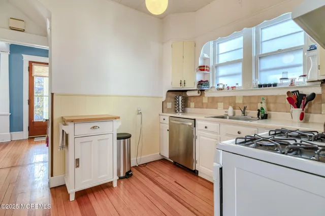 a kitchen with white cabinets and appliances