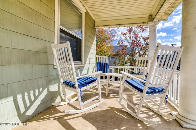 a view of a patio with table and chairs and floor to ceiling window with wooden floor