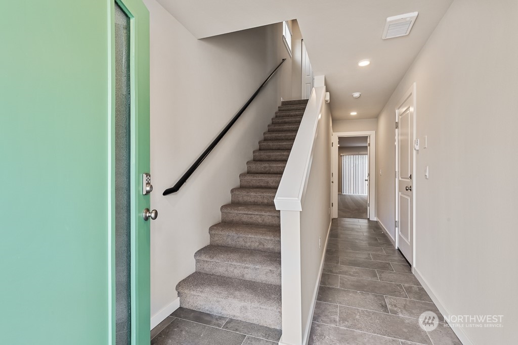 301 207th Place Southeast, Unit EH 31 Bothell, WA 98012 - Photo 3 of 32 a view of staircase with lots of frames on wall and a window