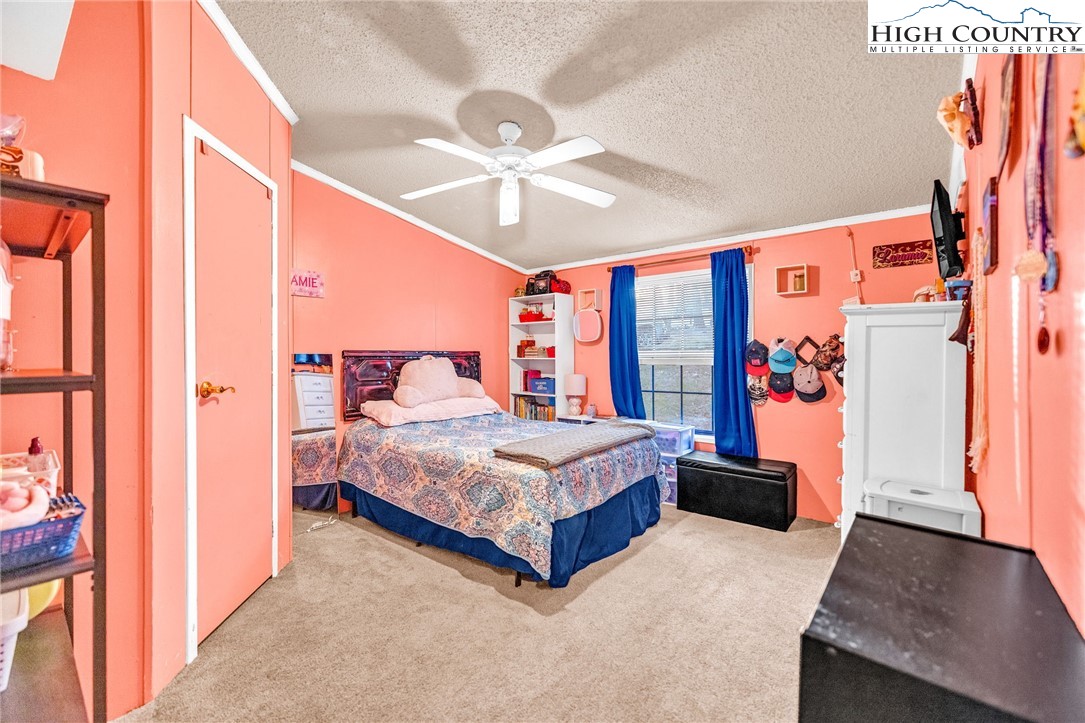 747 Nathans Creek School Road Crumpler, NC 28617 - Photo 26 of 42 a spacious bedroom with a large bed and a chandelier