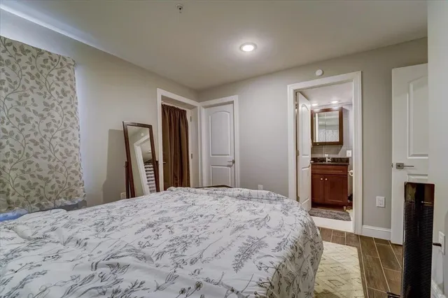 a large bedroom with a bed and a view of kitchen