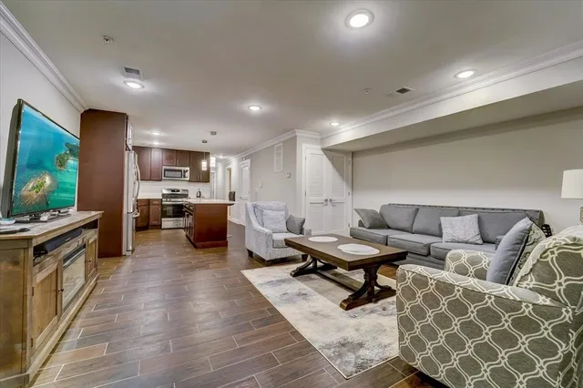a living room with furniture kitchen view and a large window