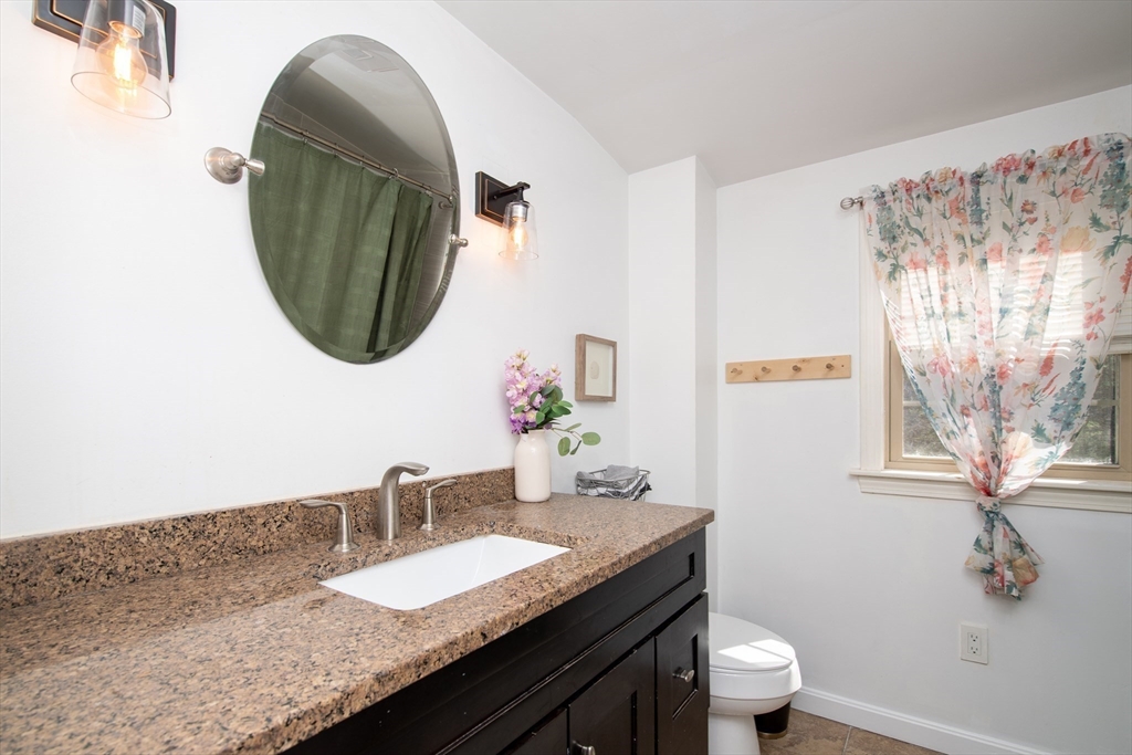 78 Precinct Street Taunton, MA 02718 - Photo 27 of 41 a bathroom with a granite countertop sink a toilet and a mirror