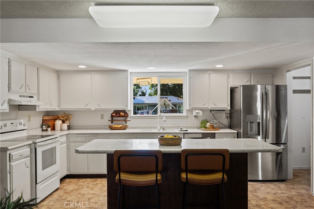 657 Villa Drive Chico, CA 95973 - Photo 16 of 40 a kitchen with stainless steel appliances a sink a stove a refrigerator and cabinets