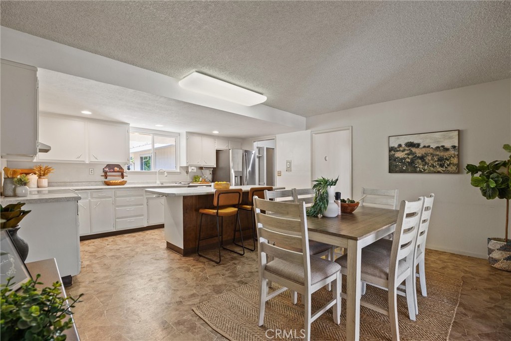 657 Villa Drive Chico, CA 95973 - Photo 19 of 40 a kitchen with a dining table chairs and white cabinets