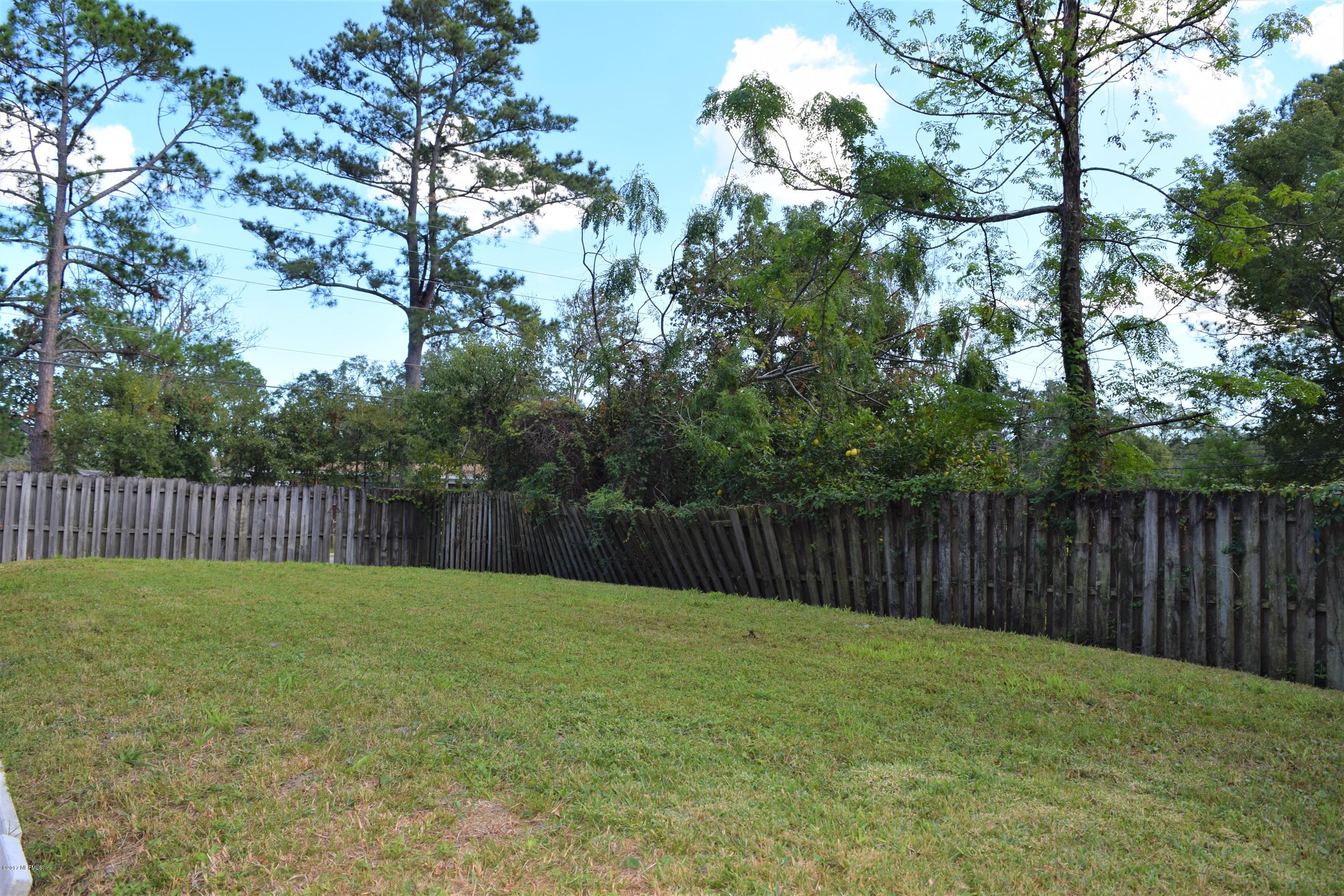6658 Bennett Road Jacksonville, FL 32216 - Photo 18 of 19 a view of a backyard with a fence and trees