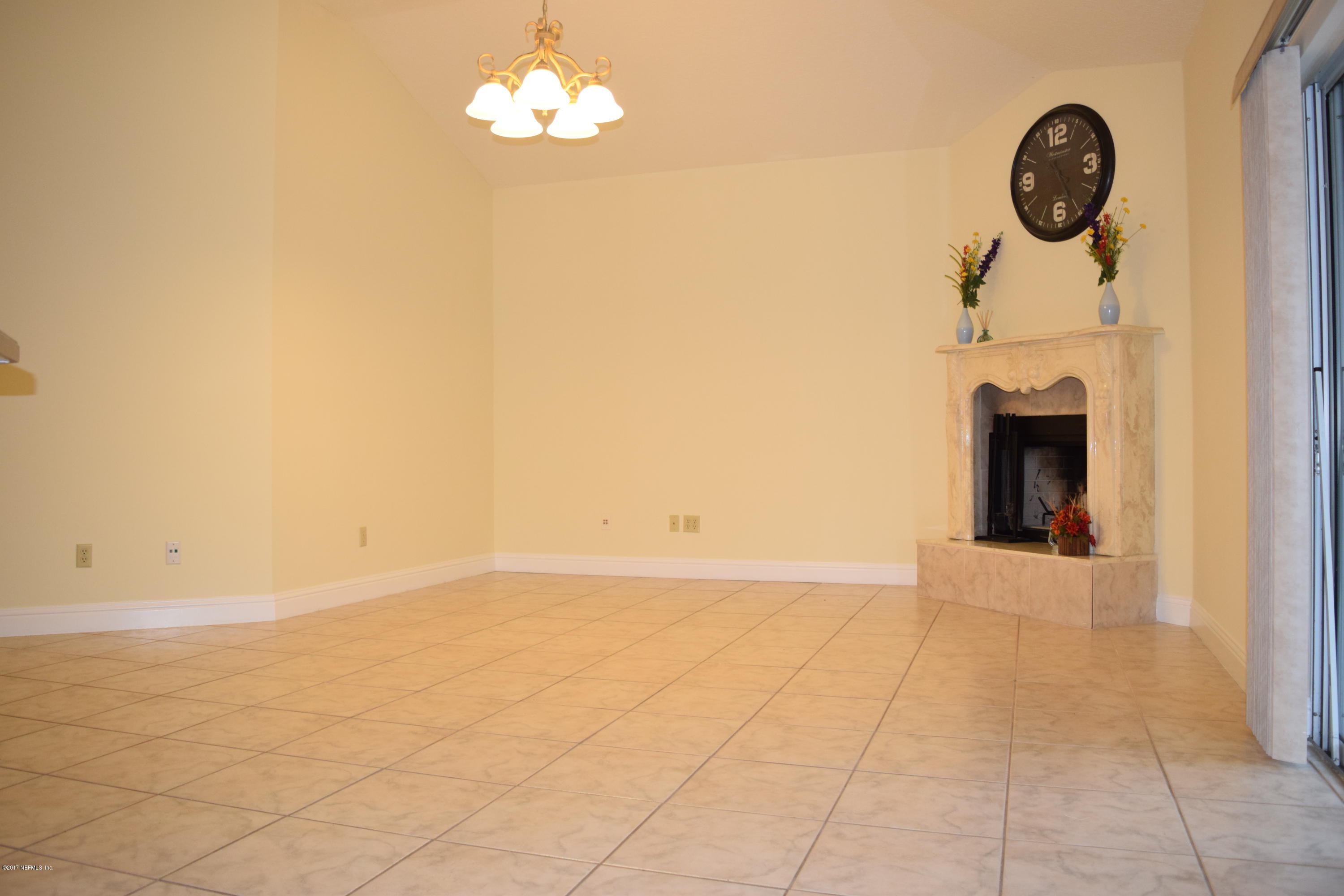 6658 Bennett Road Jacksonville, FL 32216 - Photo 3 of 19 an empty room with a fireplace and chandelier