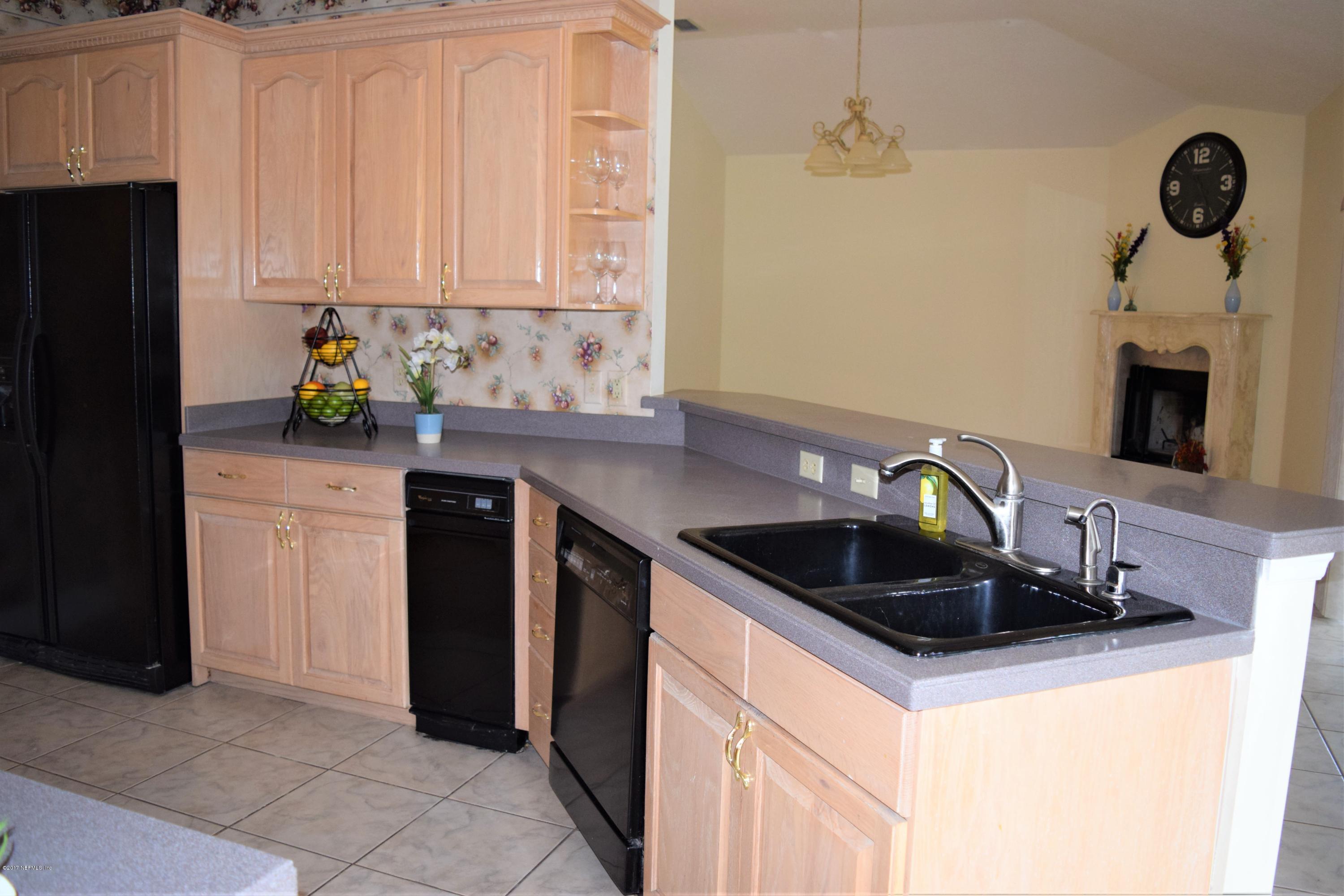 6658 Bennett Road Jacksonville, FL 32216 - Photo 4 of 19 a kitchen with granite countertop a sink a stove and cabinets