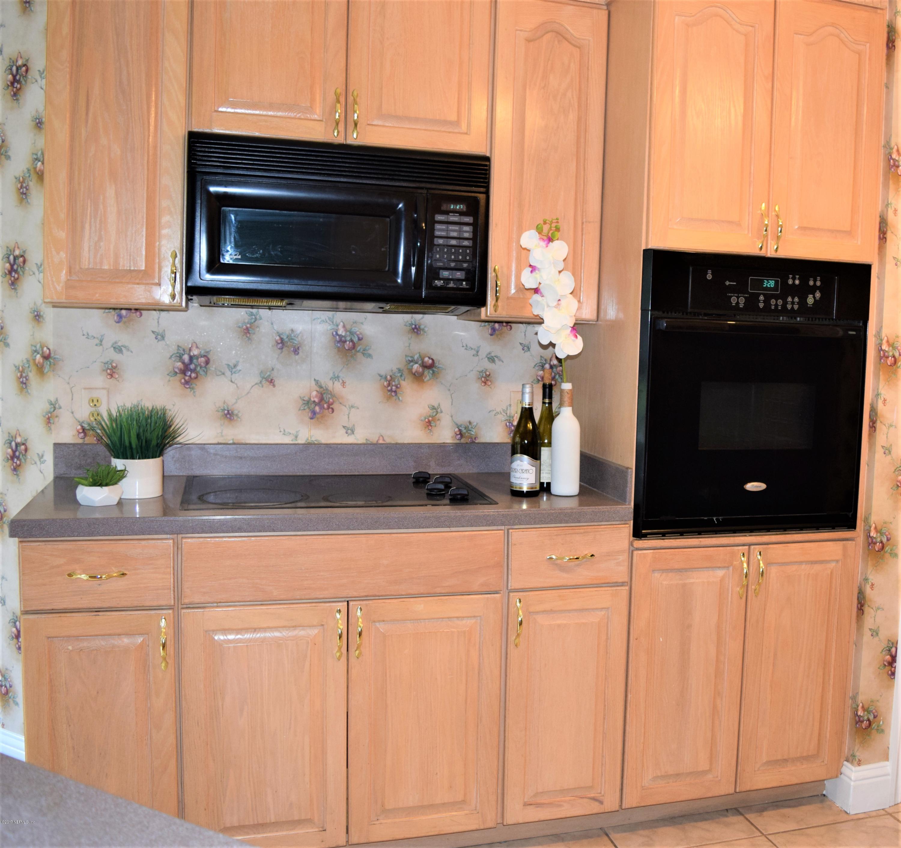 6658 Bennett Road Jacksonville, FL 32216 - Photo 6 of 19 a kitchen with granite countertop white cabinets and black appliances